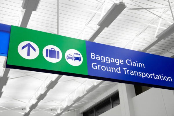 Airport,Baggage,Claim,And,Ground,Transportation,Sign,With,Suitcase,,Bus,